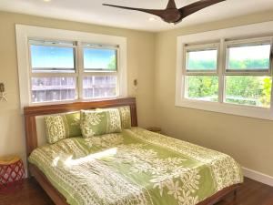 a bedroom with a bed and two windows at Beautiful Guest House Kailua Beach in Kailua