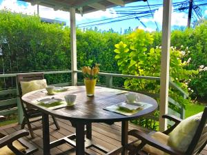 カイルアにあるBeautiful Guest House Kailua Beachの椅子付きのポーチに座る木製テーブル
