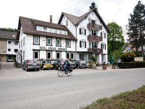 バート・ヘレンアルプにあるHotel Kühler Brunnen mit Gästehausの建物前の通りを自転車に乗る者
