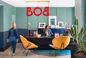 two women in an office with a bd sign and chairs at Bob Hotel in Paris