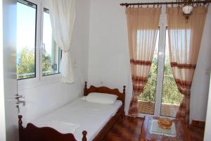 a bed in a room with a window at Eleni Houses in Kómboi