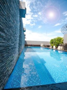 a swimming pool with blue tiles on the side of a building at Sleep Withinn in Bangkok