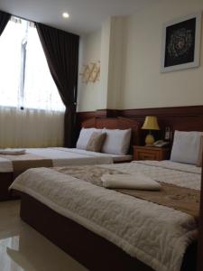クイニョンにあるAu Lac Hotelのベッドが2つと窓があるホテルの部屋