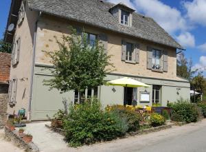 a building with an umbrella in front of it at L'Auberge de Teissières in Teissières-lès-Bouliès