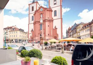 een groot gebouw met een klokkentoren in een stad bij Hotel Platzhirsch in Fulda