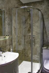 ein Bad mit einer Dusche, einem Waschbecken und einem WC in der Unterkunft King Alfred Hotel in Barrow in Furness