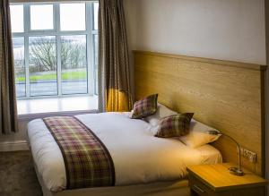 Un dormitorio con una cama y una ventana grande. en King Alfred Hotel, en Barrow-in-Furness