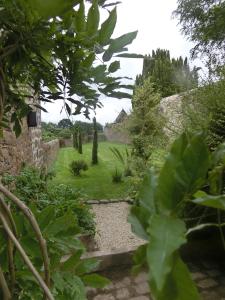 un jardin avec un mur en pierre et un chemin dans l'établissement Ti Hazhou, à Hédé