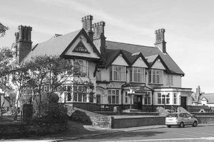 ein großes Haus mit einem davor geparkt in der Unterkunft King Alfred Hotel in Barrow in Furness