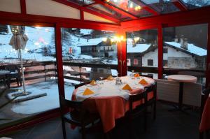 uma mesa num restaurante com vista para um pátio coberto de neve em Pensione Cari em Molare