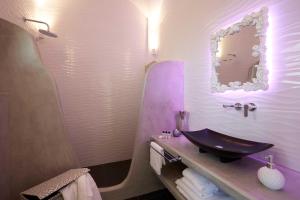 ein Badezimmer mit Waschbecken und Spiegel in der Unterkunft Amara Suites Santorini in Kamari