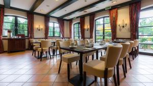 a dining room with a table and chairs at Hotel Ohlenhoff in Norderstedt