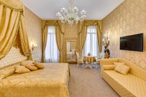 a bedroom with a bed and a couch and a television at Residenza Veneziana in Venice