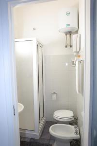 bagno bianco con servizi igienici e lavandino di L'ANGOLO DI SAN MICHELE a Trapani