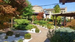 a garden with bushes and trees and a building at Hotel Gio in Arad