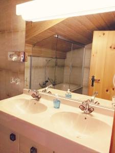 uma casa de banho com um lavatório e um espelho grande em Ambiente Mountain Style em Saas-Fee