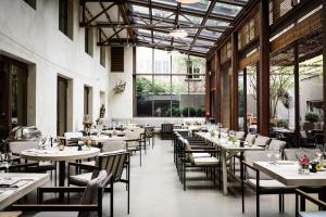 a dining room with tables and chairs and windows at Hotel Bayerischer Hof in Munich