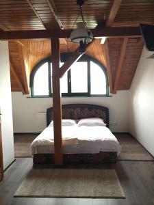 1 dormitorio con 1 cama en una habitación con ventanas en Kantár Fogadó és Étterem, en Vitnyéd