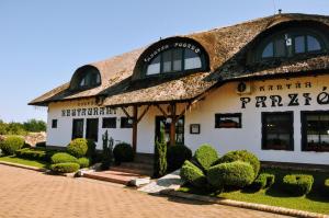 a large white building with a thatched roof at Kantár Fogadó és Étterem in Vitnyéd