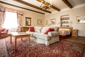 a living room with a couch and a table at Hotel Dvur Hoffmeister in Velké Číčovice