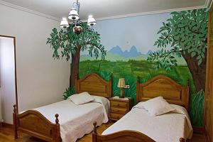 a bedroom with two beds and a painting on the wall at Casa Rural Zubiarena in Satrústegui