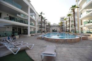 einen Pool in einem Gebäude mit Liegestühlen in der Unterkunft City Resort Palmore in Eilat