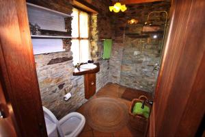 a bathroom with a stone shower with a toilet at Casa Campelo in Cedeira
