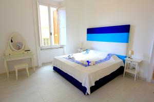 フォルミアにあるB&B Vitruvio Suitesのベッドルーム1室(青いヘッドボードと鏡付きのベッド1台付)