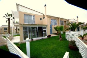 a house with a white fence in front of a yard at B4 Waterfront in Swakopmund