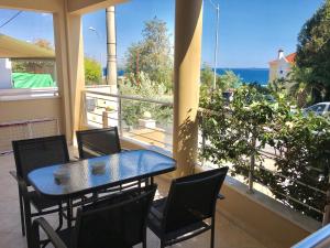 a table and chairs on a balcony with a view of the ocean at Aris studios in Kavála