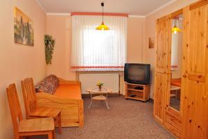 a living room with a couch and a tv at Pension "AM RENNSTEIG" in Eisenach