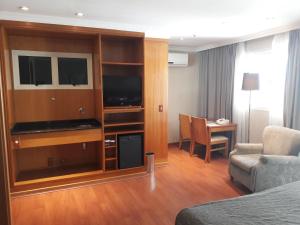 una habitación de hotel con un gran centro de entretenimiento en Barra First Class, en Río de Janeiro