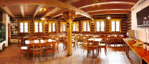 a restaurant with wooden tables and chairs in a room at Bret CZ in Žacléř