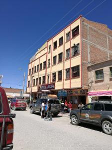 a city street with cars parked in front of a building at Hotel Julia in Uyuni