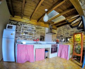 a kitchen with a refrigerator and a counter top at Casa Quintas dos Mouros in Montederramo
