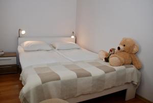two teddy bears sitting on a bed in a bedroom at Apartment AMUR in Kraków