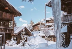 a snow covered yard in front of a lodge at Les Fermes de Marie in Megève