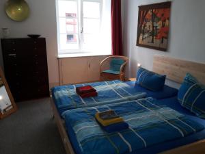 コンスタンツにあるAltstadtapartment Wilder Mannのベッドルーム1室(青いシーツと椅子付)