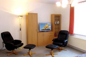 a waiting room with three chairs and a television at Ferienwohnung Schlupp in Dresden