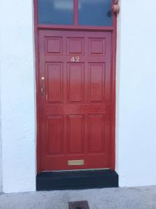 une porte rouge avec son numéro dans l'établissement Wexford Town Opera Mews - 2 Bed Apartment, à Wexford