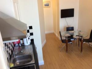 une cuisine et une salle à manger avec une table et une télévision dans l'établissement Wexford Town Opera Mews - 2 Bed Apartment, à Wexford