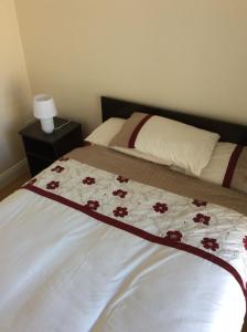 ウェックスフォードにあるWexford Town Opera Mews - 2 Bed Apartmentのベッドルーム1室(赤い花のベッド1台付)