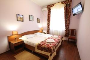a bedroom with a bed and a television and a window at Hotel Troya in Kostroma