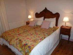sypialnia z dużym łóżkiem z kolorową narzutą w obiekcie Le Jardin Andrinople w mieście Richelieu