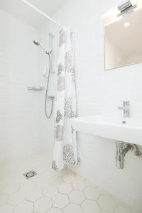 biała łazienka z umywalką i zasłoną prysznicową w obiekcie Mere Puiestee Apartment w Tallinnie