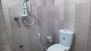 uma casa de banho com um chuveiro e um WC. em Shrine Inn em Kandy