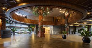 un vestíbulo con árboles y plantas en un edificio en The Crystal Luxury Bay Resort Nusa Dua, en Nusa Dua