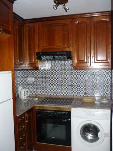 トレビエハにあるApartamento Las Atalayas 3 Torreviejaのキッチン(木製キャビネット、洗濯機、乾燥機付)