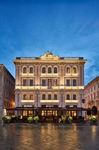 a large building in the middle of a street at Grand Hotel Duchi d'Aosta in Trieste