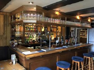 a bar with blue stools in a pub at The Game Cock Inn in Austwick